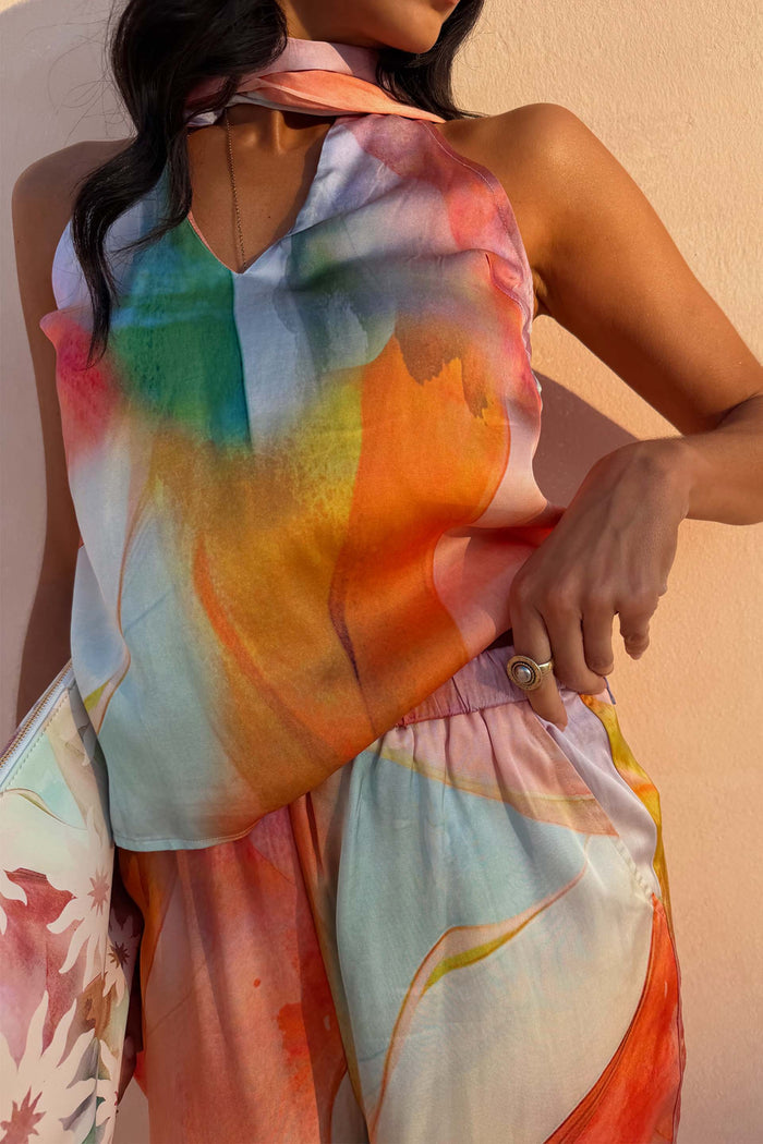 Abstract Naomi Trousers in a bold multicoloured print, styled as a co-ord with a matching halter top.