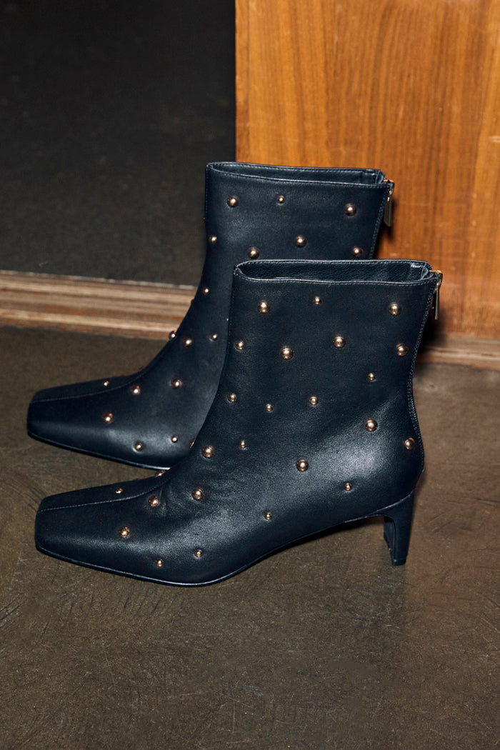 Black leather ankle boots with gold studs, a square toe and thin block heel, designed in London.