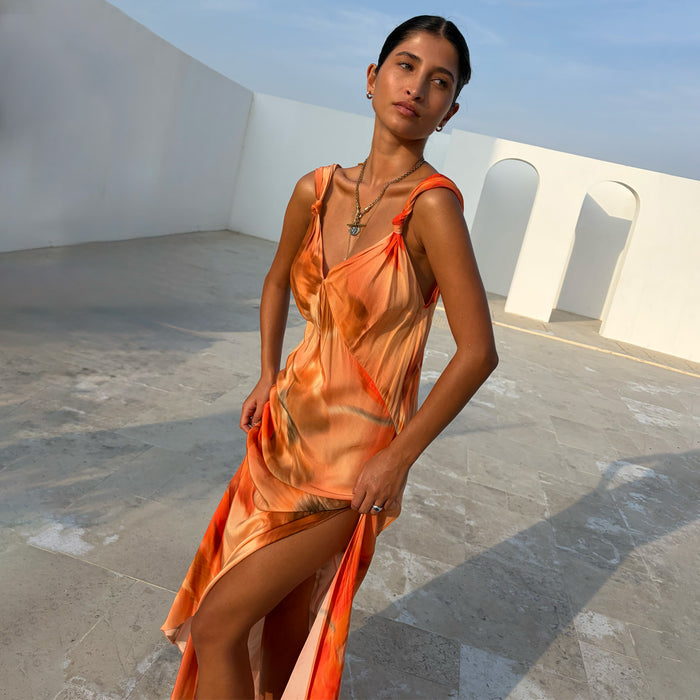 Blurred Floral Sofia Dress in burnt orange featuring tie-knot shoulders and a fluid bias-cut side slit.