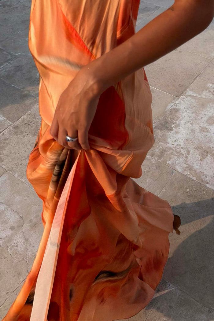 Burnt orange Blurred Floral Sofia Dress highlighting the fluid bias-cut drape and side slit.