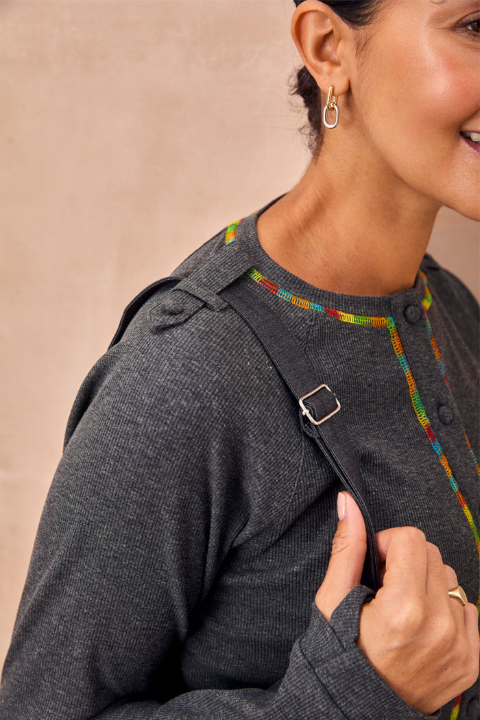 Charcoal Life is Tough Honey Drainage Bag strap worn over a grey ribbed top with vibrant rainbow stitching.