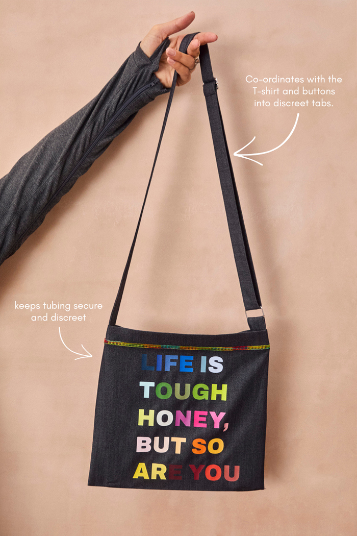 Charcoal Life is Tough Honey Drainage Bag featuring multicoloured text, rainbow stitching and an adjustable strap.