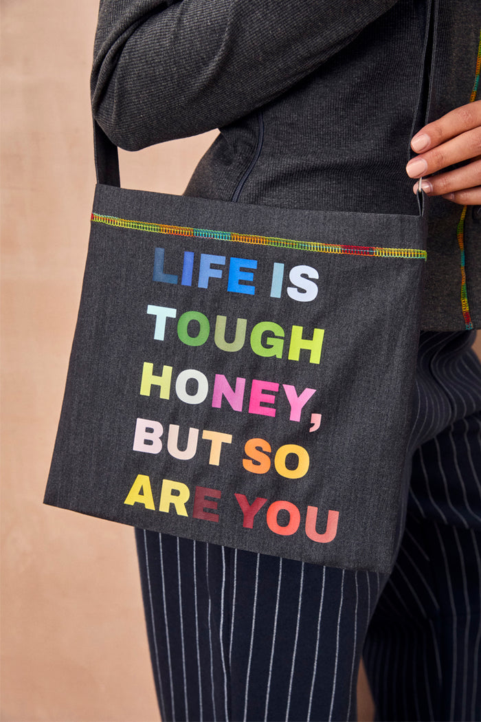 Charcoal Life is Tough Honey Drainage Bag with a rainbow 'Life Is Tough Honey, But So Are You' slogan and top stitching.