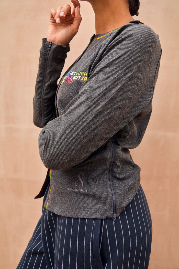Charcoal grey Honey T-Shirt with multicoloured slogan embroidery and functional side zips for treatment accessibility.