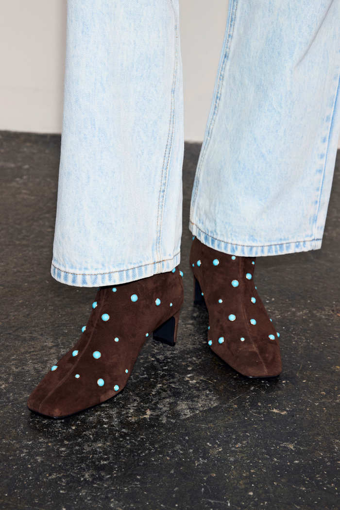 Chocolate Studded Suede Boots in brown suede with turquoise studs, a square toe and block heel, worn with light jeans.