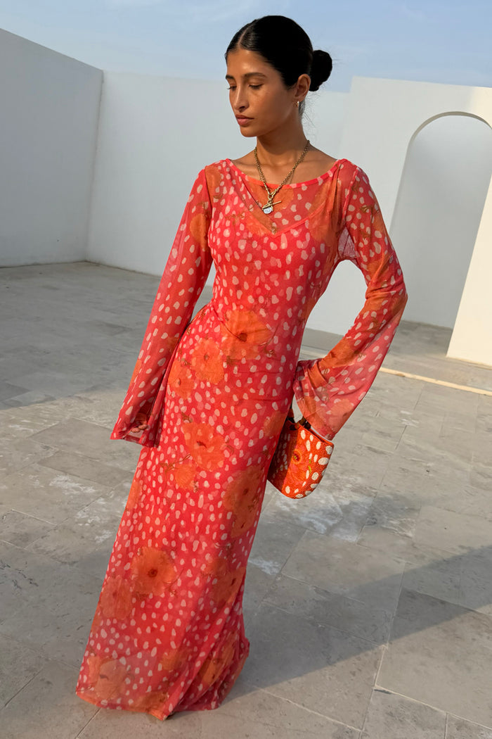 Coral pink Aria Dress in sheer mesh with iconic poppy and fawn prints, featuring flared sleeves and a midaxi length.