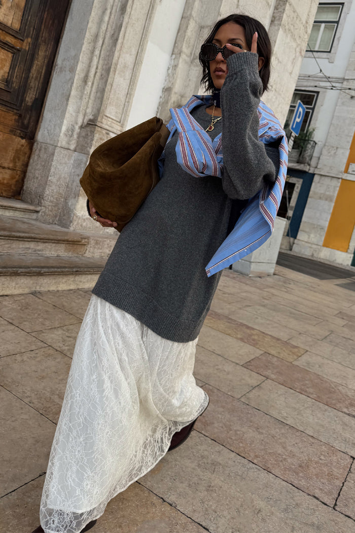Grey Knit Jumper Dress with a sheer cream lace skirt, styled with a blue striped shirt for a chic London look.