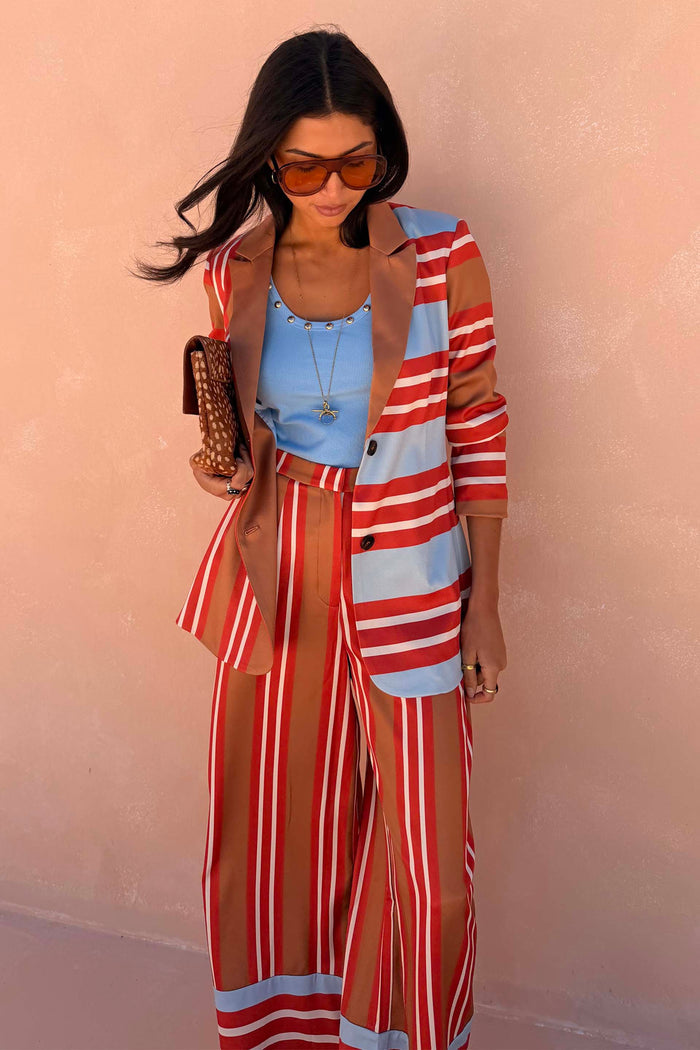 Multi Stripe Blazer in red and blue satin with a longline fit, paired with matching trousers and a blue top.