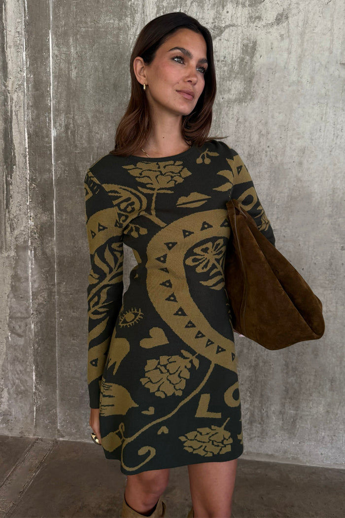 Olive Amara Knit Mini Dress featuring yellow icon motifs, styled with a large brown bag.