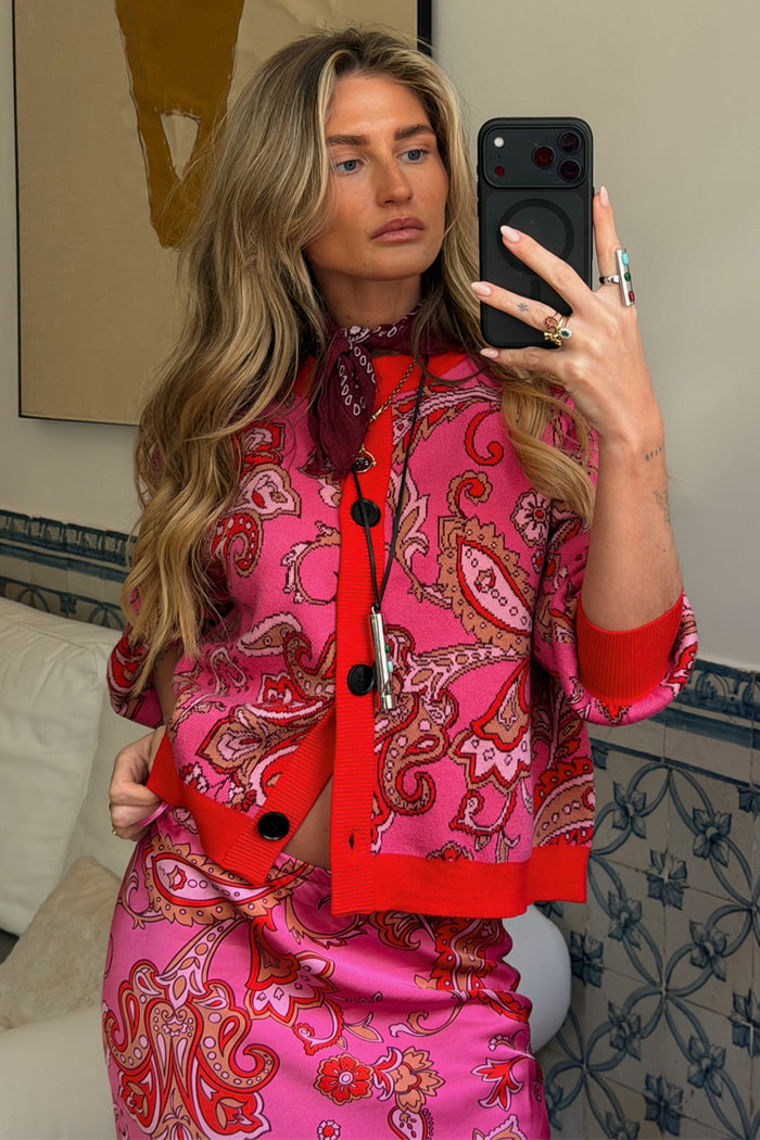 Pink Paisley Oslo Cardigan with red ribbed trims and a boxy fit, styled with a matching skirt in a mirror selfie.