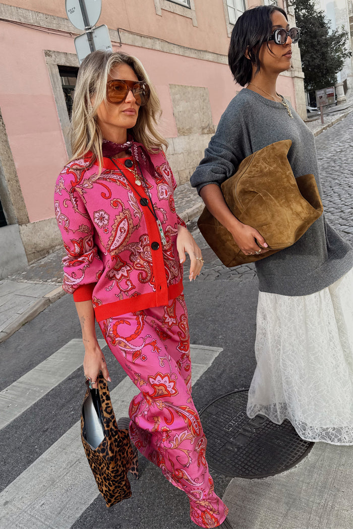 Pink Paisley Oslo Cardigan with red trims and matching trousers, paired with a leopard bag for a London look.