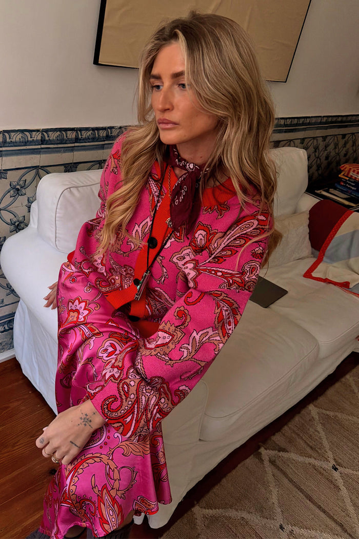 Pink Paisley Oslo Cardigan in a soft knit with red ribbed trims, styled with a matching skirt for a bold London look.