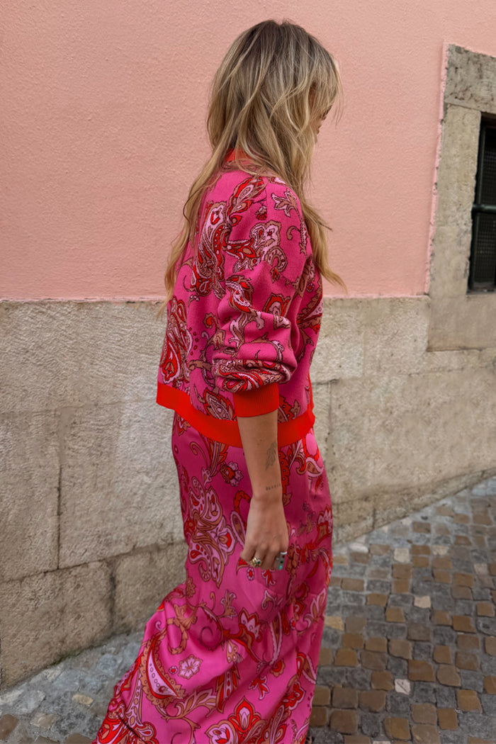 Pink Paisley Oslo Cardigan with an intricate red print and ribbed cuffs, worn as a dopamine dressing co-ord.