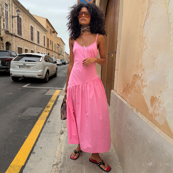 Pink Strappy Nova midaxi dress with a dropped waist and full skirt, styled with accessories for a summer city look.
