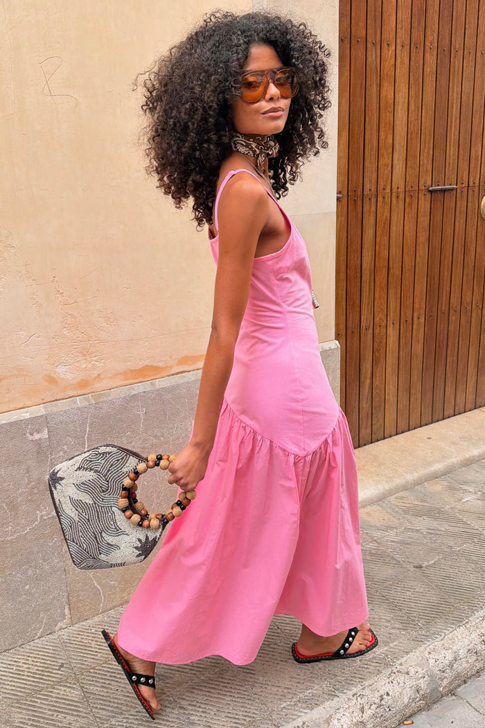 Pink Strappy Nova midaxi dress with a dropped waist and full skirt, styled for a vacation look.
