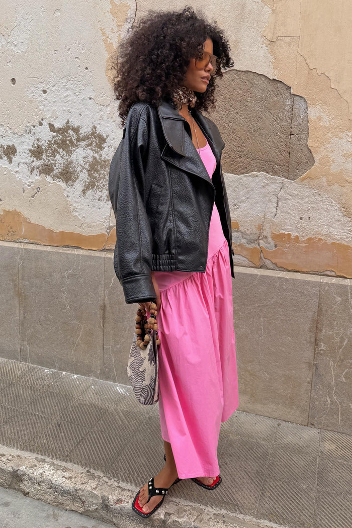 Pink Strappy Nova cotton dress with a dropped waist, layered with a leather jacket for a London street style look.