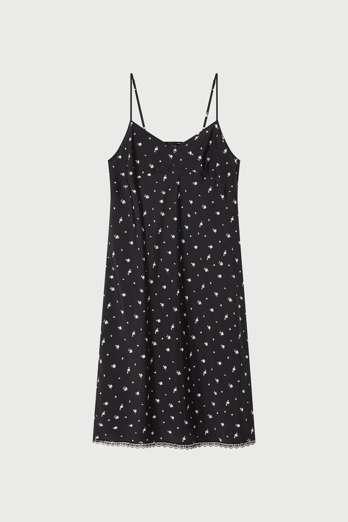 Black slip dress with white floral pattern on a light gray background